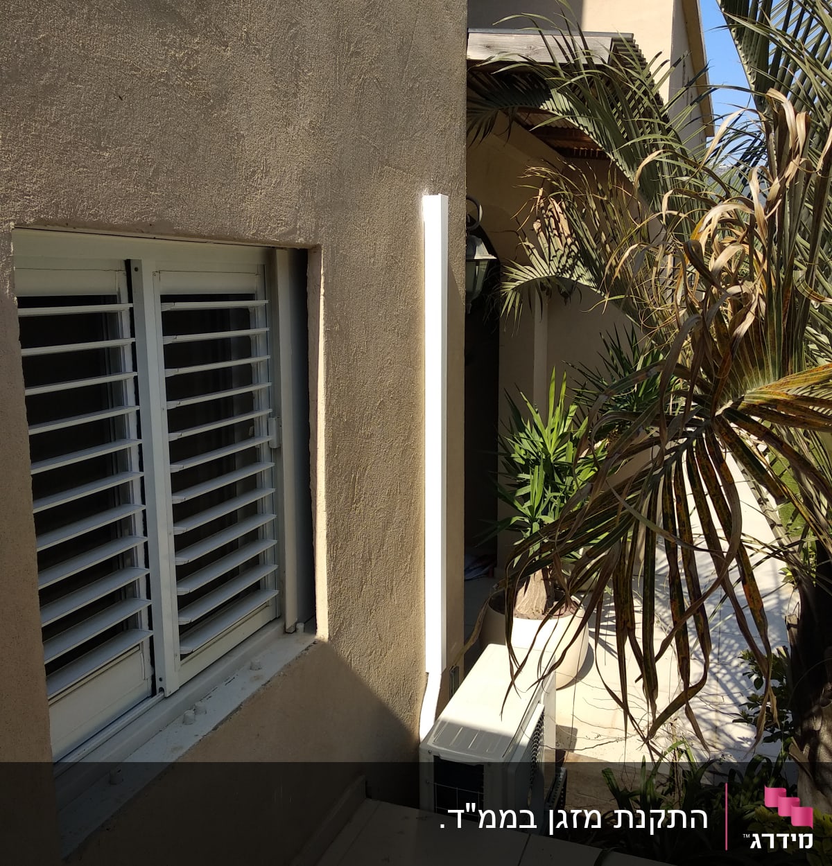 יחידת מזגן חיצונית מותקנת ליד קיר חיצוני